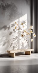 Delicate white flowers in a vase cast shadows on a concrete wall.