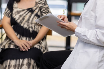 Pregnant woman listening to doctor explaining medical test results. Pregnant woman listens to...