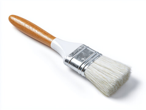 A paint brush with a wooden handle and white bristles lying on a white surface in a studio setting
