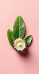 Cream jar with leaves on soft pink backdrop, top-down view