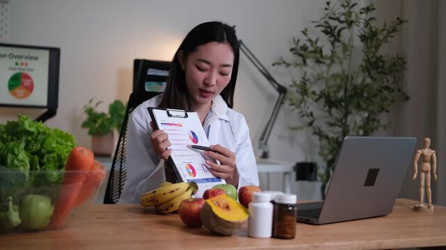 Female nutritionist showing health charts on a clipboard during an online consultation about diet and wellness.