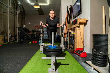 Woman pushing weighted sled during strength training session