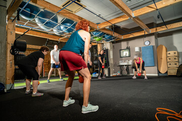 Diverse group of adults performing kettlebell fitness training