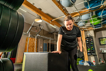 Woman exercising with dumbbell doing strength training in gym