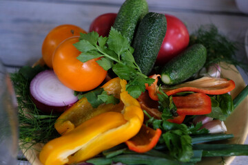 Fresh assortment of colorful vegetables including cucumbers, tomatoes, onions, and bell peppers with herbs