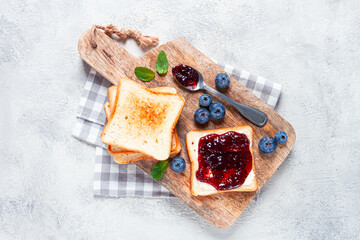 toast with blueberry jam, on a wooden chopping board, breakfast, homemade, no people,