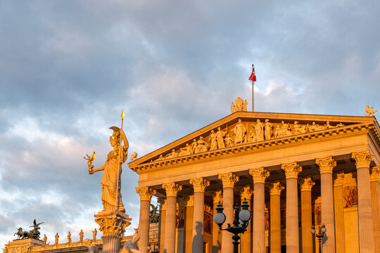 Historic Classical Building with Statue in Golden Dawn Light and Soft Morning Sky