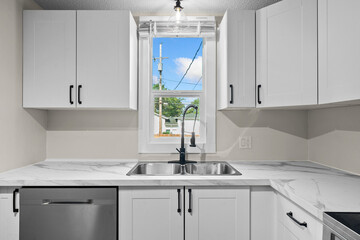 Kitchen with white cabinets and a window