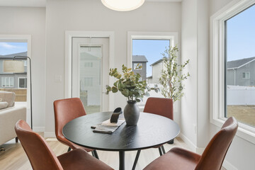 Table with four chairs and a vase of flowers in the center
