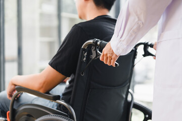 Caregiver pushing young man in wheelchair through hospital corridor, compassionate healthcare and patient support scene