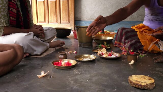 Close-up of Shivling pooja with milk, flowers, and bael leaves being offered. Indian people performing sacred havan on the occasion of Mahashivratri, offering ghee to the holy fire during  Vedic puja.