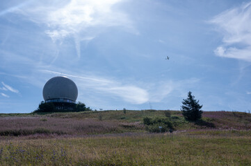 Radar dome on the Wasserkuppe with a glider in the blue sky