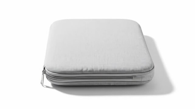 A softly lit, off-white, rectangular, padded case with a zipper closure. The case casts a soft shadow on a bright white background