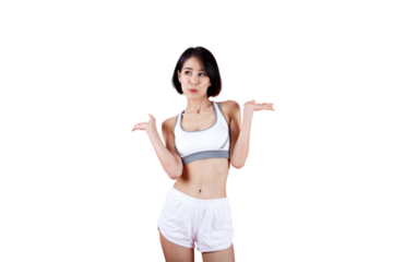 Fit young woman in sportswear standing with a confused expression and shrug gesture on pink background, representing uncertainty, decision, or choice concept.