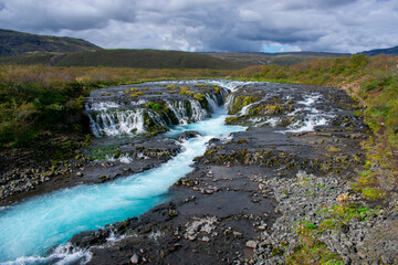 Wide River with Turquoise Water and Small Waterfalls
