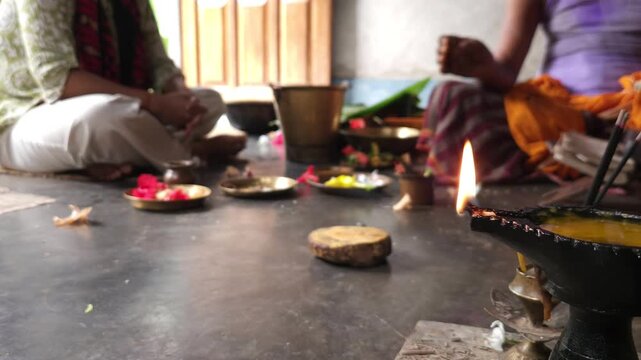 Close-up of Shivling pooja with milk, flowers, and bael leaves being offered. Indian people performing sacred havan on the occasion of Mahashivratri, offering ghee. Focused on foreground