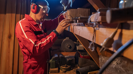 The repairman selects a spare part from the boxes on the shelves.