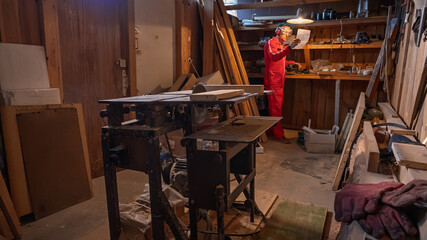 A man reads a note under the light of a lamp hanging overhead.