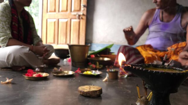 Close-up of Shivling pooja with milk, flowers, and bael leaves being offered. Indian people performing sacred havan on the occasion of Mahashivratri, offering ghee. Focused on foreground