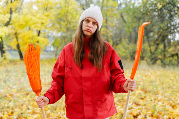 A young woman stands in a park surrounded by vibrant fall foliage