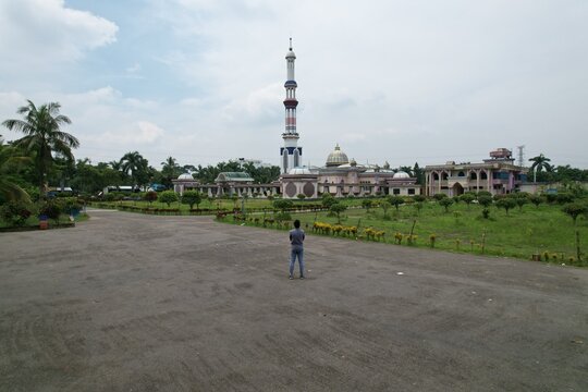 Stunning Baitul Aman Jame Masjid Complex in Barisal Bangladesh: Tranquil Landmark Islamic Architecture and Garden with Solitary Figure On Paved Square