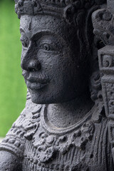 Obraz premium Close-up macro detail of a traditional Balinese statue. The porous texture of the black volcanic lava stone carving shows intricate craftsmanship