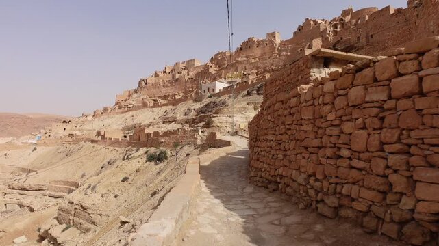 Walking through narrow pathways in beautiful Berber village of Chenini, located on a rugged mountain ridge in Tunisia
