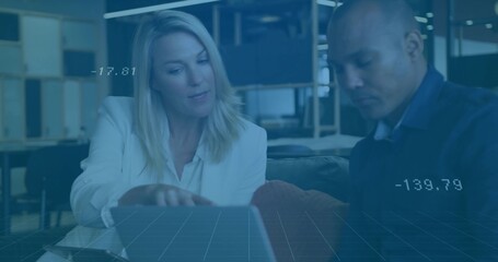 Collaborating colleagues analyzing data overlay on laptop at coffee table in office lounge