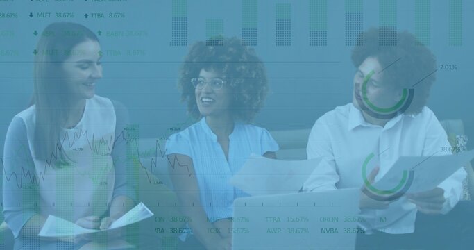 Reviewing three professionals in workwear discussing printed documents and tablet in office lounge