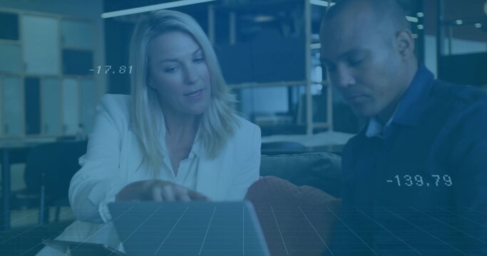 Collaborating colleagues analyzing data overlay on laptop at coffee table in office lounge