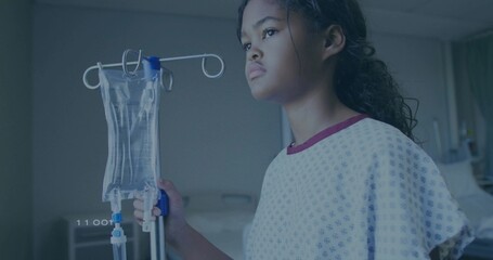 Holding IV pole with IV bag, child patient wearing purple gown in hospital room, copy space