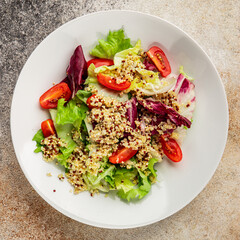 Quinoa salad tomato, green leaf salad vegetables dish natural product tasty snack fresh gourmet food background on the table rustic top view copy space keto and paleo diet vegan and vegan food