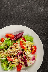 Quinoa salad tomato, green leaf salad vegetables dish natural product tasty snack fresh gourmet food background on the table rustic top view copy space keto and paleo diet vegan and vegan food
