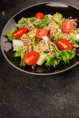 Quinoa salad tomato, green leaf salad vegetables dish natural product tasty snack fresh gourmet food background on the table rustic top view copy space keto and paleo diet vegan and vegan food