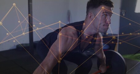 Mid adult man performing barbell deadlift in gym workout area, with rubber mat and network overlay