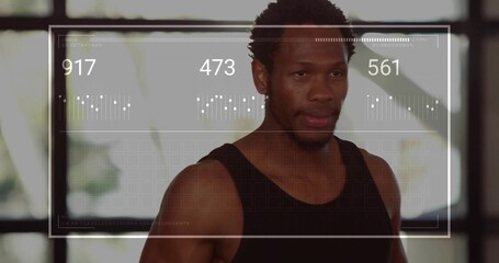 Displaying numeric readouts across torso of athlete wearing black tank top in gym with window grid