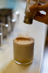 coffee in glass with cinnamon pouring