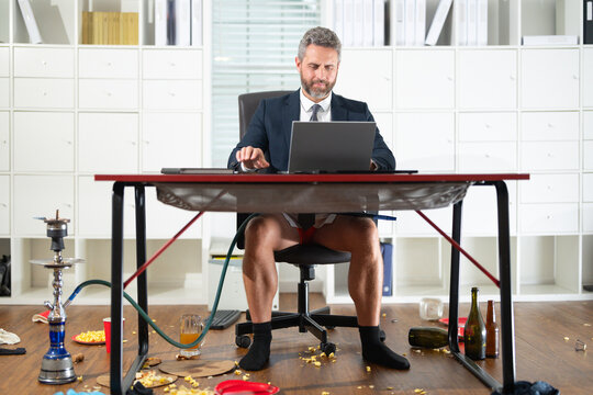 Business man in shorts and socks during a video conference in messy home office. Crazy and funny concept. Freelancer online works on laptop. Fun business team online. Messy funny office workspace. - Powered by Adobe
