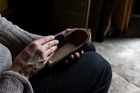 A craftsman sands a model wooden boat