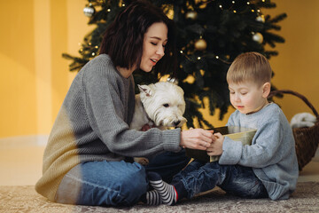 Mother, child, and dog opening christmas presents