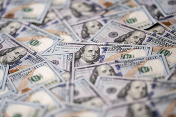 Money background with 100-dollar bills. Texture of US currency. 100 USD banknotes in focus. American hundred-dollar notes spread on a table. Pattern of US dollars for finance concept.