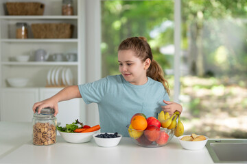 Child eating healthy breakfast at home kitchen. Child at the kitchen dining table. Happy kid having tasty lunch in the modern kitchen. Child during family meal. Teen child eat dinner in white kitchen.