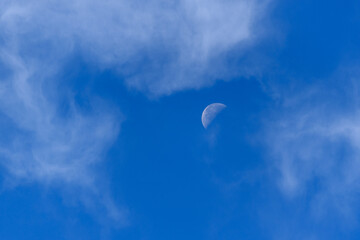 Half Moon in Blue Sky with Wispy Clouds