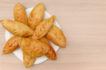 Homemade baked pies on a white plate. A delicious appetizer.