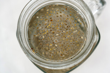 Adding soaked chia seeds close up, detox water. Preparing superfood water drink rich in Omega 3 fatty acids. Clean eating, weight loss, dieting food concept.