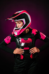 Woman in pink motocross gear prepares for an exciting ride in vibrant surroundings