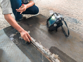 Inspectors are checking defects in welded steel plate add joints with process Ultrasonic testing (UT) of Non-Destructive Testing(NDT) at the industrial factory.