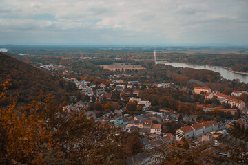 High-angle autumnal panoramic view of the town of Hainburg an der Donau, Austria, from the Hainburg Castle ruins, showing the Danube River and a distant cable-stayed bridge