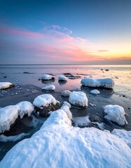Icy coastal scene with snow-covered rocks at dawn's pastel light