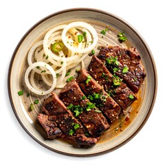 Gourmet sliced grilled steak with onion rings and garnish on a round plate